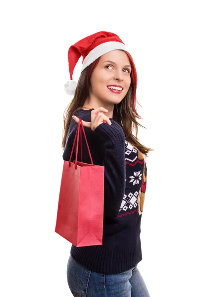 穿着冬装的女孩戴着圣诞老人的帽子，拿着一个购物袋 — 图库照片
