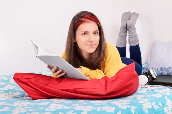 Retrato de una chica en su cama leyendo un libro — Foto de Stock