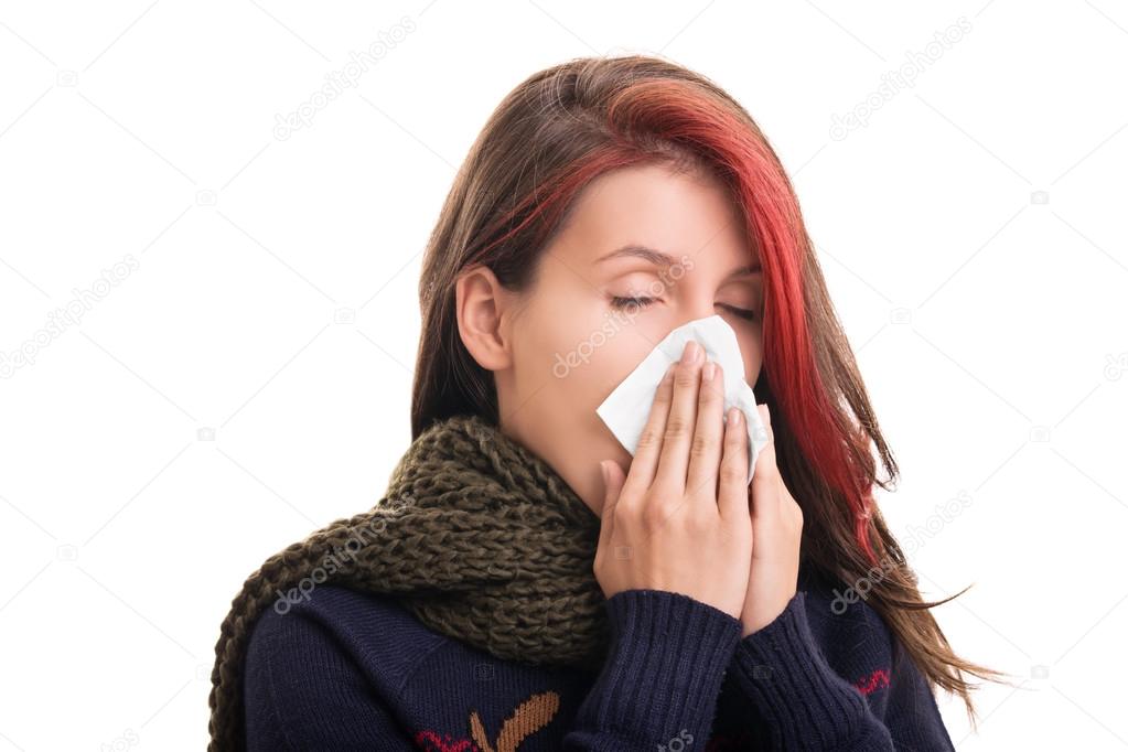 Portrait of a girl in winter clothes blowing her nose