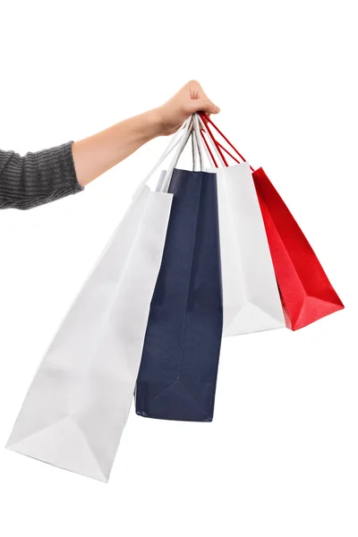 Mão feminina segurando sacos de compras isolados no fundo branco — Fotografia de Stock