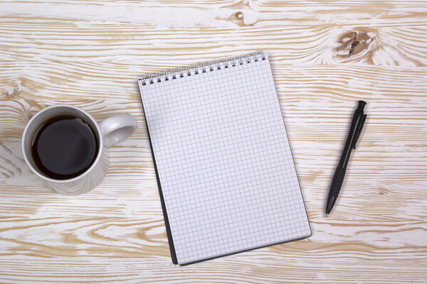 notebook with pen and mug  on wooden table