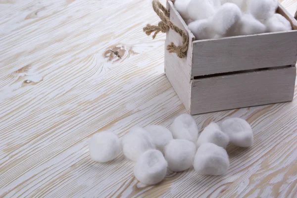 Bolas de algodão em uma caixa na mesa de madeira — Fotografia de Stock