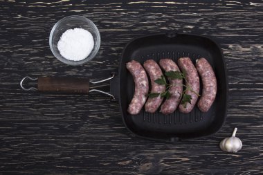 tavada ahşap zemin üzerine sarımsaklı çiğ sosis