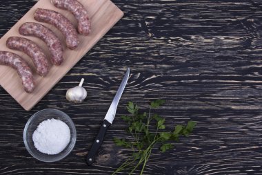 Kesme tahtası üzerinde çiğ sosis.