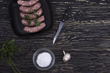 tavada ahşap zemin üzerine sarımsaklı çiğ sosis