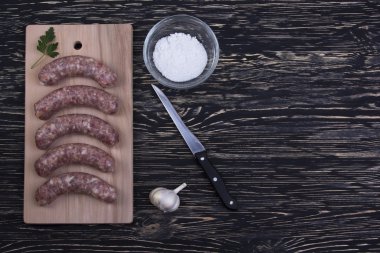 Kesme tahtası üzerinde çiğ sosis.