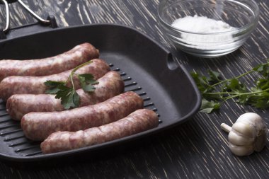 çiğ sosis tava, tuz ve sarımsak, ahşap arka plan