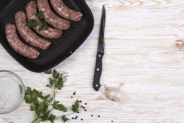 çiğ sosis tava, tuz, bıçak, sarımsak, ahşap arka plan