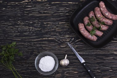tavada ahşap zemin üzerine sarımsaklı çiğ sosis