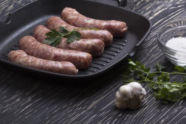 çiğ sosis tava, tuz ve sarımsak, ahşap arka plan