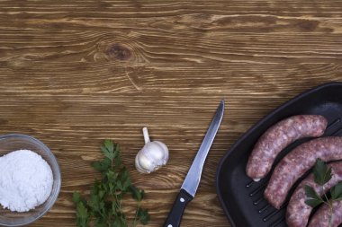 çiğ sosis tava, tuz, bıçak, sarımsak, ahşap arka plan