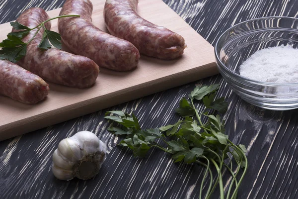 Çiğ sosis, tuz ve sarımsak ahşap tablo