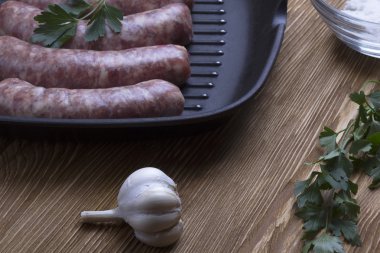 çiğ sosis tava, tuz ve sarımsak, ahşap arka plan