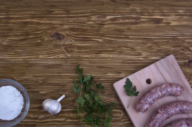 Çiğ sosis, tuz ve sarımsak ahşap tablo