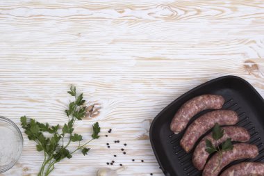 çiğ sosis tava, tuz ve sarımsak, ahşap arka plan