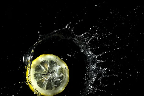 Лимонные брызги в воду — стоковое фото