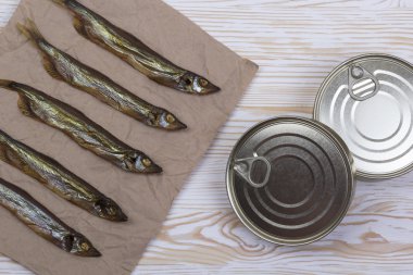 Ahşap arka plan üzerinde füme capelin ve konserve teneke