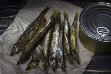 Ahşap arka plan üzerinde füme capelin ve konserve teneke