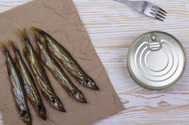 Ahşap arka plan üzerinde füme capelin ve konserve teneke