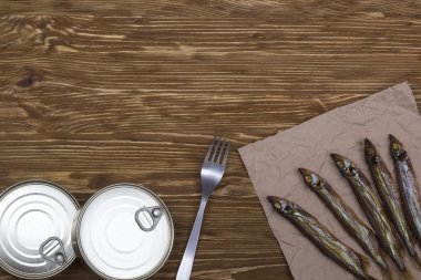 Ahşap arka plan üzerinde füme capelin ve konserve teneke