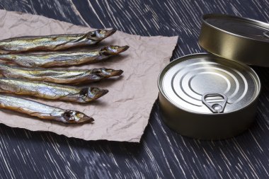 Ahşap arka plan üzerinde füme capelin ve konserve teneke