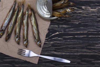 Ahşap arka plan üzerinde füme capelin ve konserve teneke