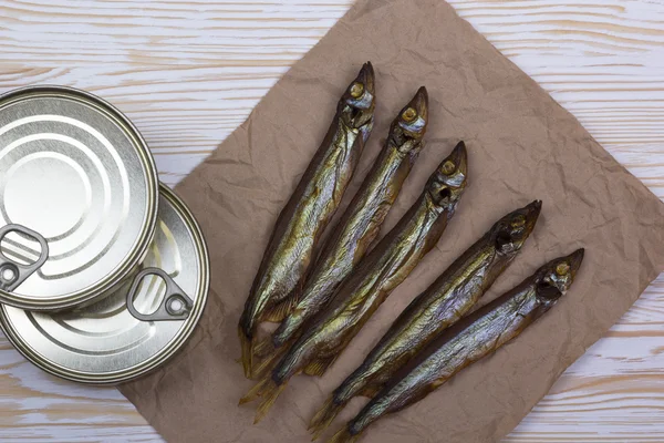 Ahşap arka plan üzerinde füme capelin ve konserve teneke