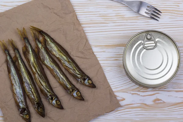 Ahşap arka plan üzerinde füme capelin ve konserve teneke