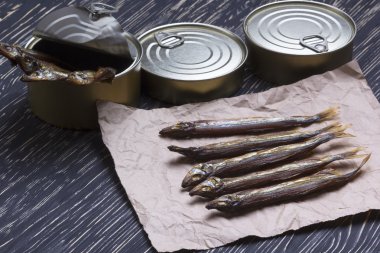 Ahşap arka plan üzerinde füme capelin ve konserve teneke
