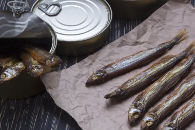 Ahşap arka plan üzerinde füme capelin ve konserve teneke