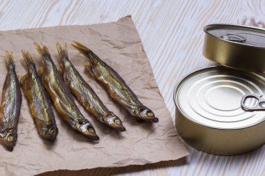 Ahşap arka plan üzerinde füme capelin ve konserve teneke