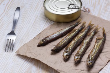 Ahşap arka plan üzerinde füme capelin ve konserve teneke
