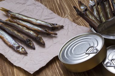Ahşap arka plan üzerinde füme capelin ve konserve teneke