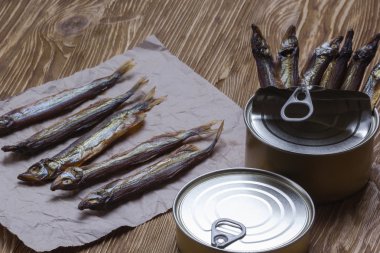Ahşap arka plan üzerinde füme capelin ve konserve teneke