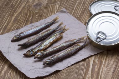 Ahşap arka plan üzerinde füme capelin ve konserve teneke