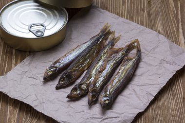 Ahşap arka plan üzerinde füme capelin ve konserve teneke
