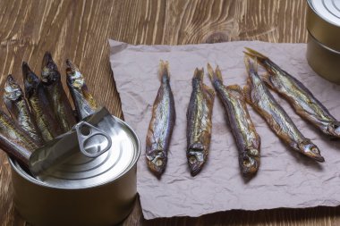 Ahşap arka plan üzerinde füme capelin ve konserve teneke