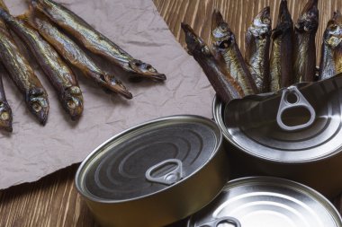 Ahşap arka plan üzerinde füme capelin ve konserve teneke