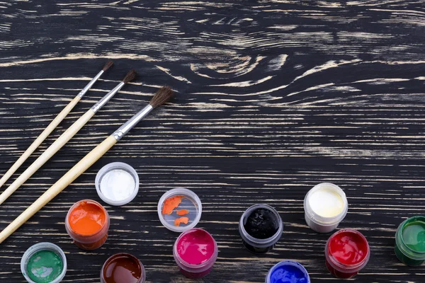 Gouache paints and brushes on wooden backgound — Stock Photo, Image