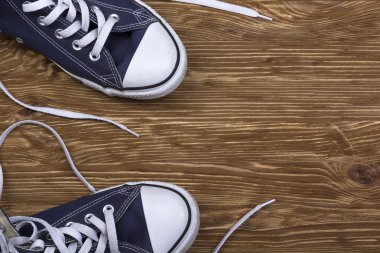 Kopya alanı ahşap zemin üzerine mavi spor ayakkabı.