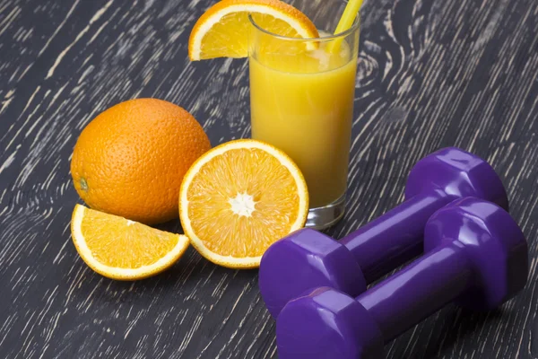 Close-up de halteres, suco de laranja, frutas e fita métrica — Fotografia de Stock