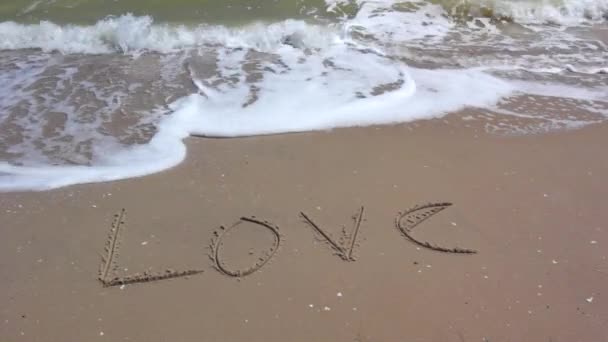 Wort Liebe Schreiben am Sandstrand. — Stockvideo