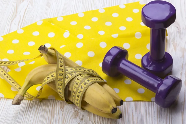 Bando de bananas, fita métrica e halteres — Fotografia de Stock
