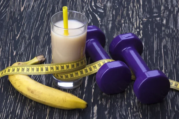 Banana, suco, fita métrica e halteres — Fotografia de Stock