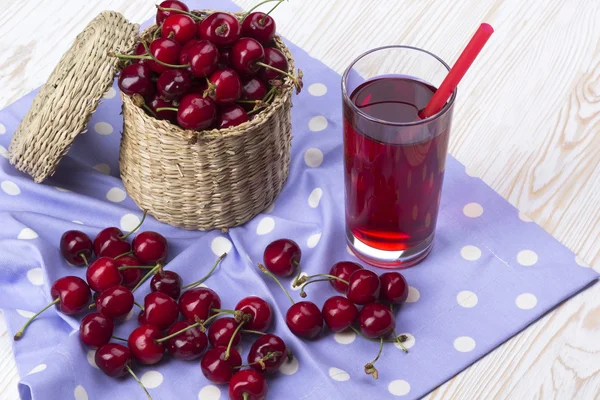 Vişne sepeti ve ahşap zemin üzerine suyu