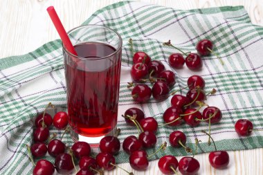 Suyu ve kırmızı kiraz ahşap bir masa üzerine