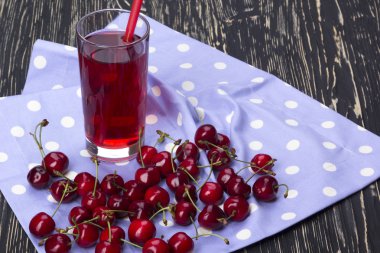 Suyu ve kırmızı kiraz ahşap bir masa üzerine