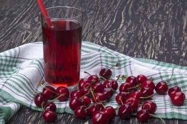 Suyu ve kırmızı kiraz ahşap bir masa üzerine