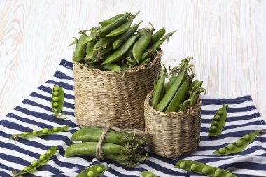 Taze organik yeşil bezelyeler sepette.