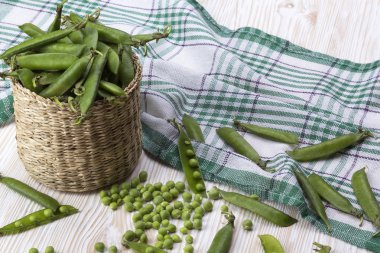 Taze organik yeşil bezelyeler sepette.